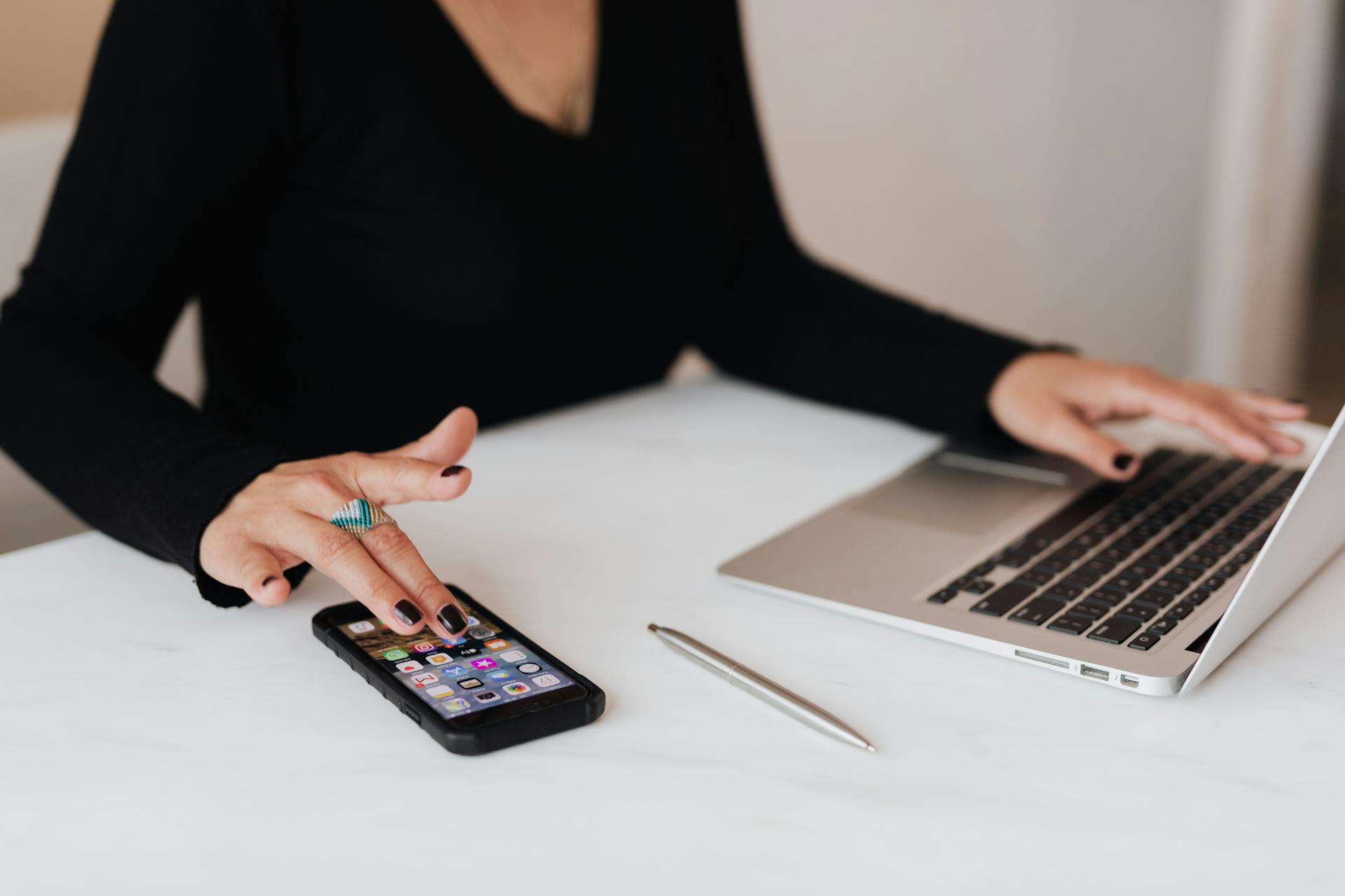 close up of woman working on laptop and using smartphone